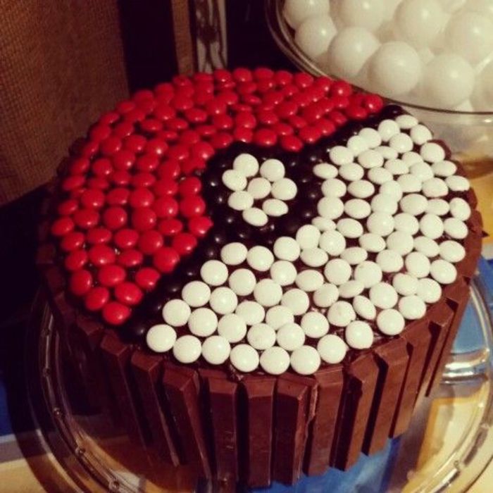 uma deliciosa torta de pokemon de chocolate com pralinês pretos, vermelhos e brancos - parece uma pokebola