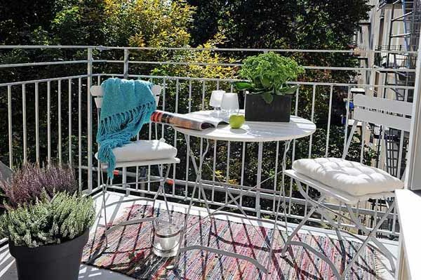 agradável terraço com cadeiras brancas e uma mesa redonda