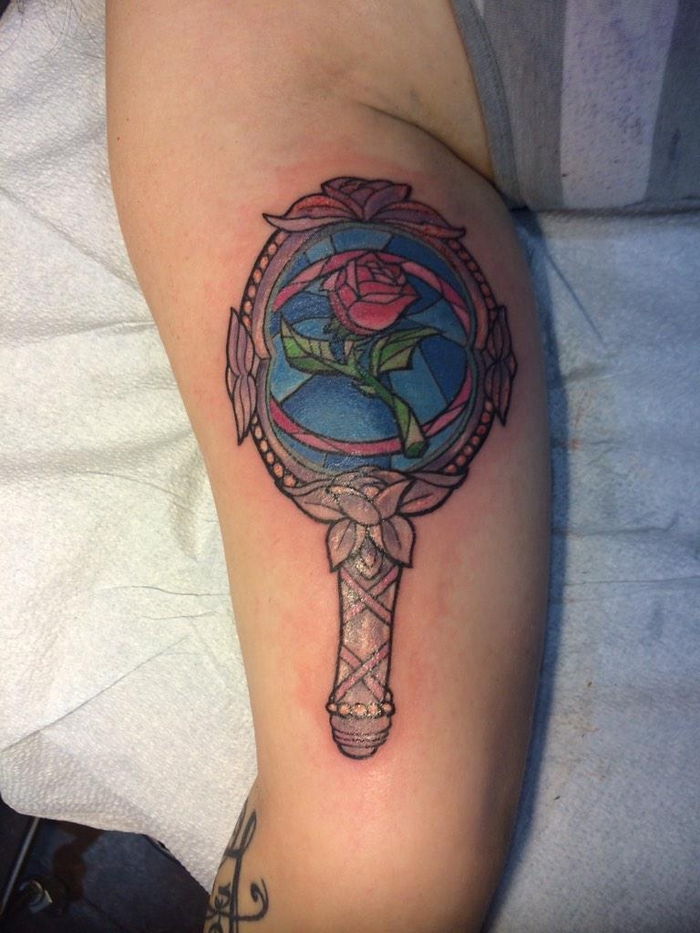 róża tatuaż z bajkowymi motywami piękna i bestia - lustro i czerwona róża z zielonymi liśćmi