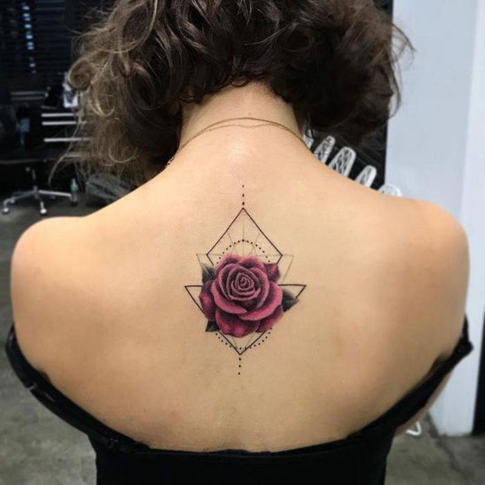 tattoo rose na vrhu - rdeča cvetoča vrtnica s tremi zelenimi listi na hrbtu ženske