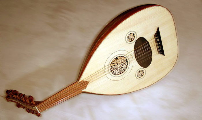 Musikinstrument: Oud med sex dubbla strängar och kort böjt handtag, framme med träsniderier och ornament