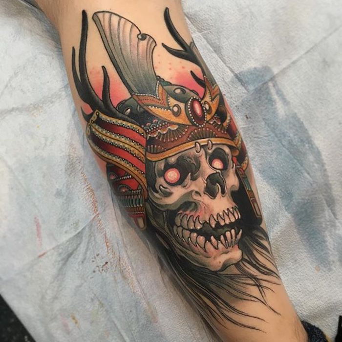 tatuagem de guerreiro, caveira com olhos vermelhos e capacete, braço