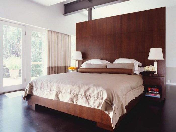 ett stort sovrum, tonårstrum i brunt färg, massor av trä och två symmetriska lampor
