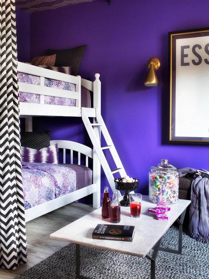 violetinės sienos iš kambario, nedidelis stalas su gėrimais, saldainiai ir 