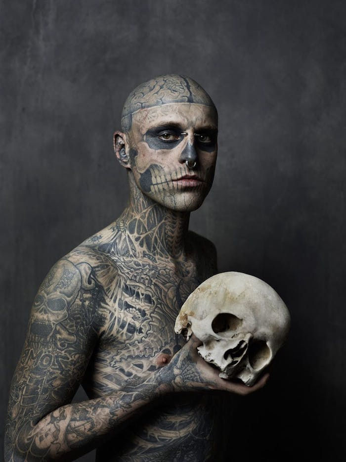 tatoveringskalle - en mann med en hvit stor hodeskalle og med mange tatoveringer - en tatovering med en stor, hvit hodeskalle med svarte øyne