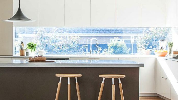 świetny projekt kuchni z białymi szafkami i szklaną tylną ścianą - okno