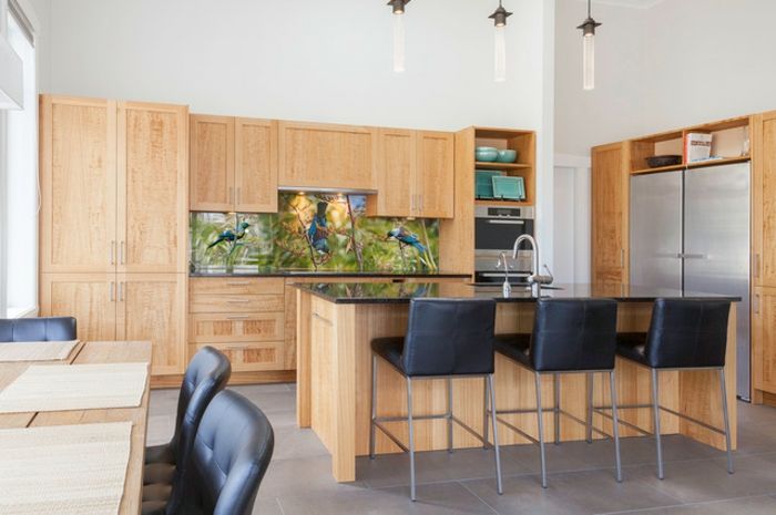 Kuchnia z drewnianymi szafkami i tylną ścianą kuchni z ptakami