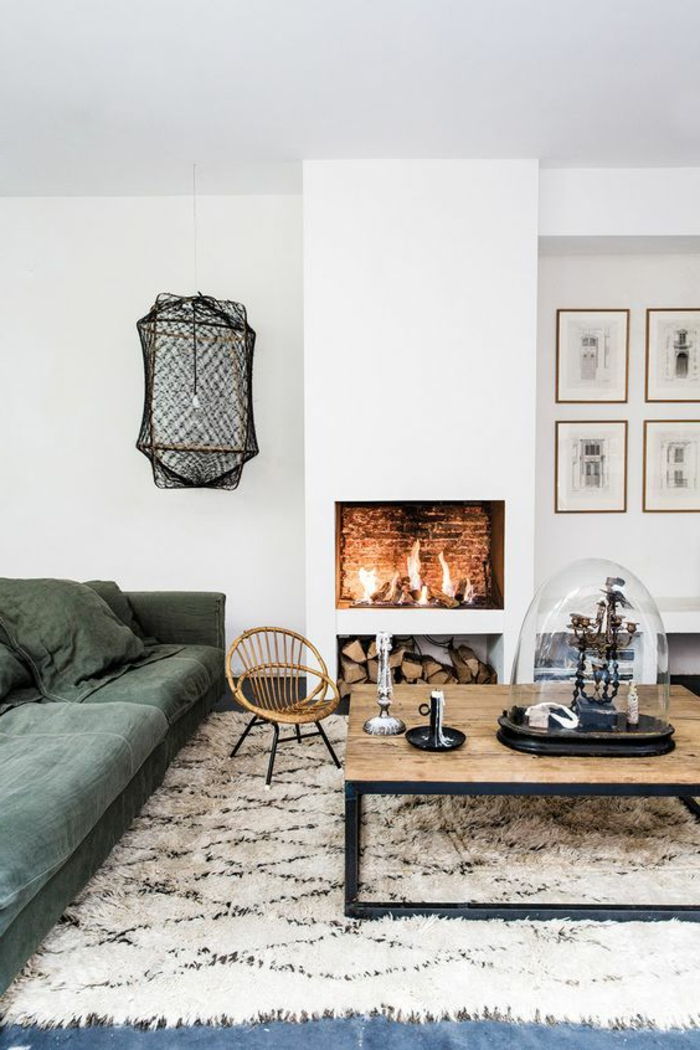 com paredes de lareira verde-sofá-padrão tapete branco-preto-café cadeira de madeira-Tischdeko-madeira mesa-sólido