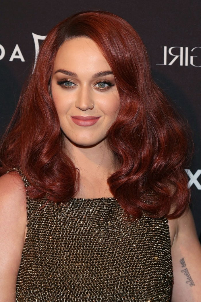 Katy Parry su tamsiais raudonais plaukais, raudonais plaukais ir mėlynomis akimis - puikus išvaizda, atsitiktinis makiažas
