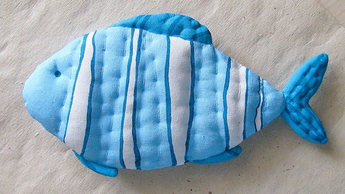 mėlyna žuvis, pagaminta ant baltos juostelės su siuvimo mašina - žaidimai katėms