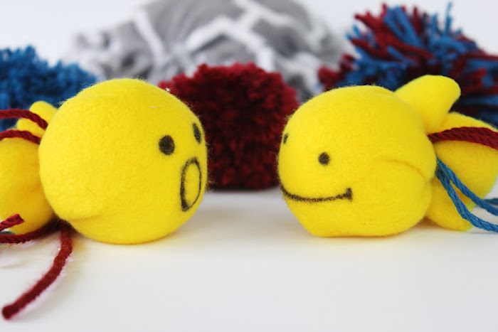 Spill for katter - to gule baller med malte ansikter og mange pompoms