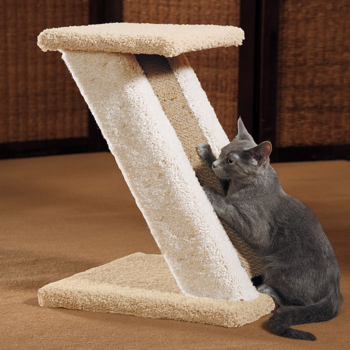 En grå katt klättrar på reppost som är gjord av olika material - vilket gör kattleksaker