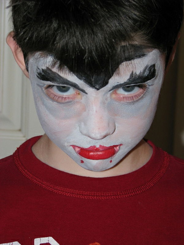 criança vampiro rosto make-up lábios em vermelho