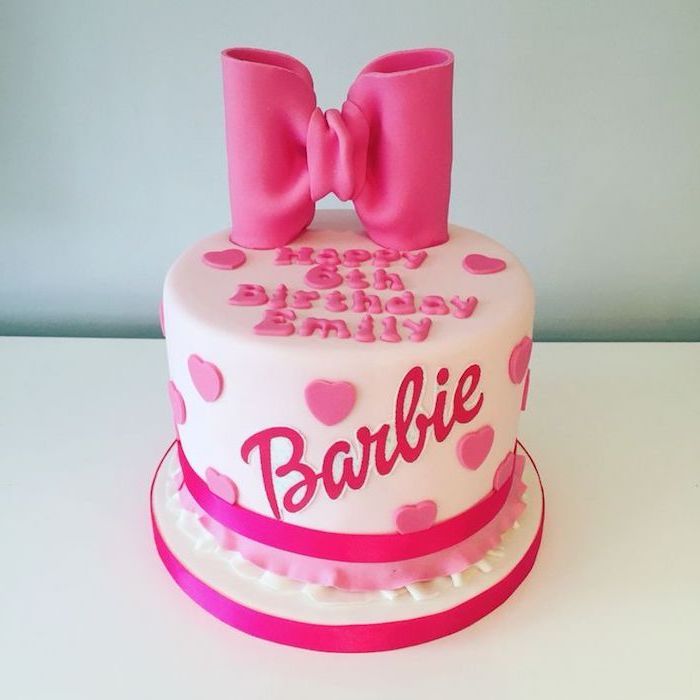 kinder taart, verjaardagstaart in roze versierd met grote strik en fondant harten