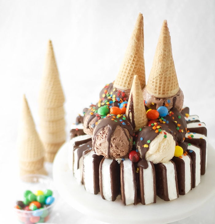 Kinder verjaardagstaart met chocolade en ijs versierd met hagelslag en kleurrijke snoepjes
