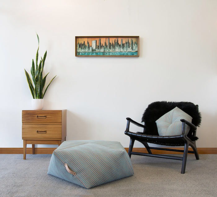 diskret design i vardagsrummet kudde på golvstolen svart mini skåp wall deco blomma