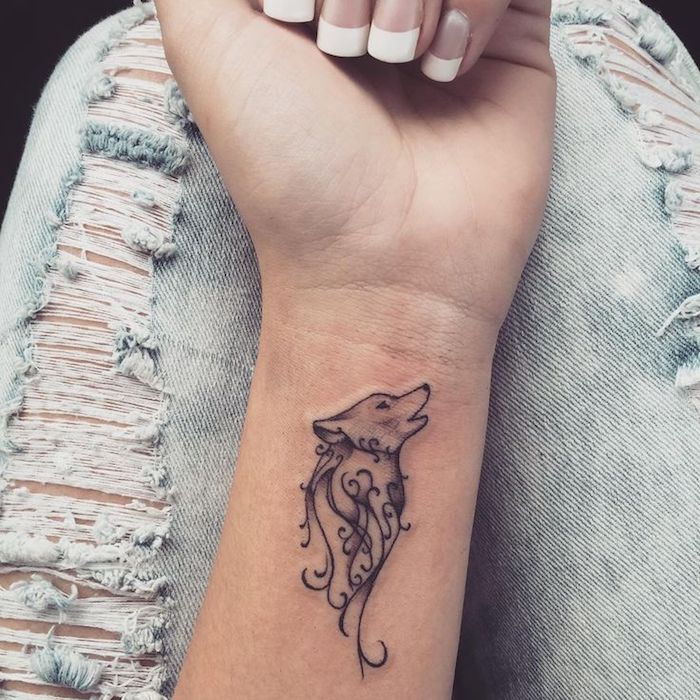 najbardziej popularne tatuaże, mały tatuaż z motywem wilka na nadgarstku