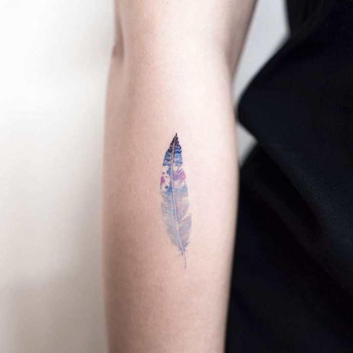 kleine tatoeage op de onderarm, waterverftatoeage met veermotief