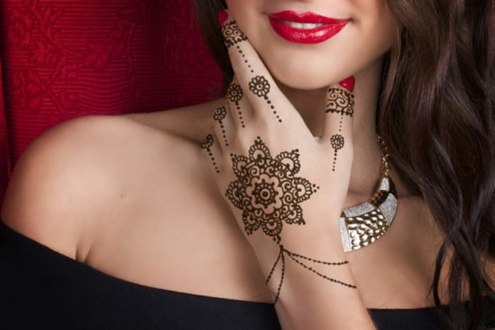 tatovering ideer midlertidig henna vakre maleri på hånden av en vakker dame rød leppestift