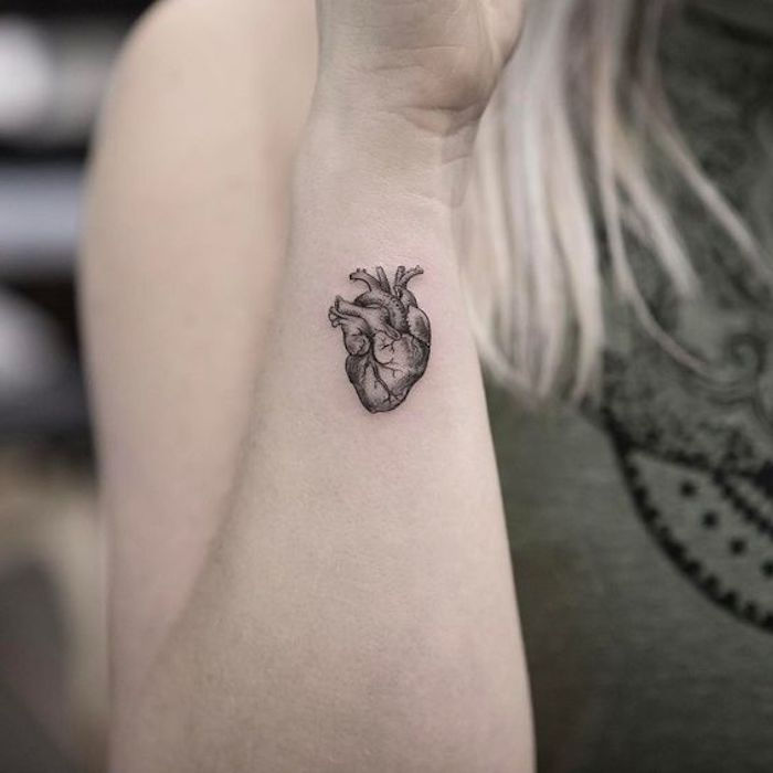Blond kvinna ger mig en mini-tatuering i form av det mänskliga hjärtat