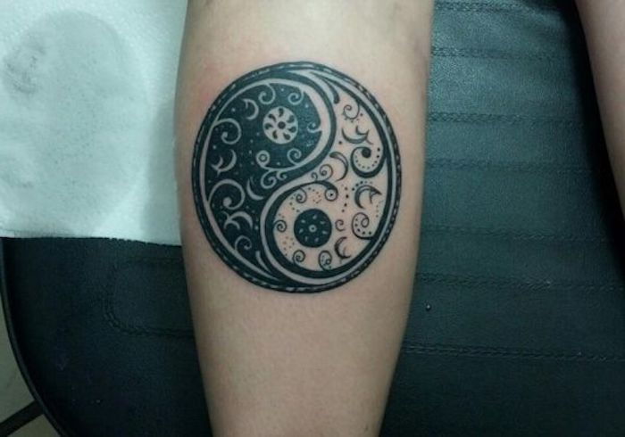 en liten tatuering med yin-yang-motivet, tatuering, spiraler, prickar