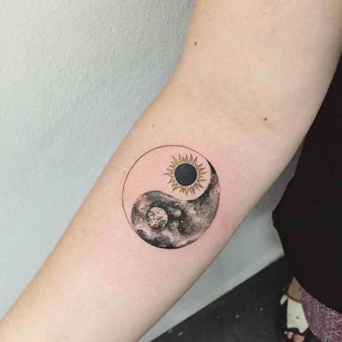 Bir kadın, güneş ve ay, siyah ve beyaz kolunda Yin-Yang dövme