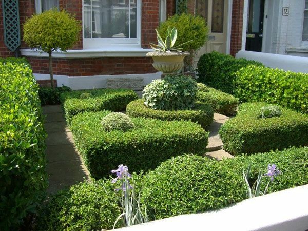 mooi huis met een tuin - groene planten en een skulprur steen