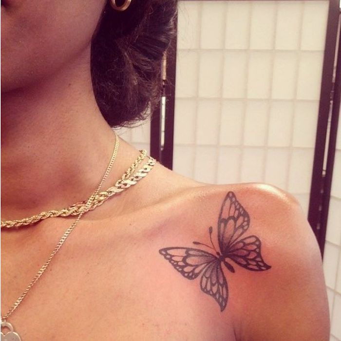 majhna tetovaža z motivom metulja v črni barvi na rami