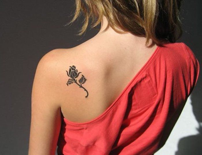 najbardziej odporne tatuaże, kobieta z czerwoną sukienką i małym różanym tatuażem