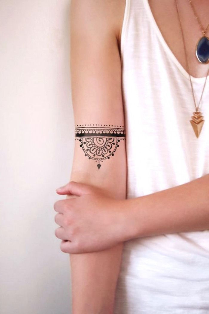 najbardziej popularne tatuaże, mały tatuaż z wieloma elementami na ramieniu