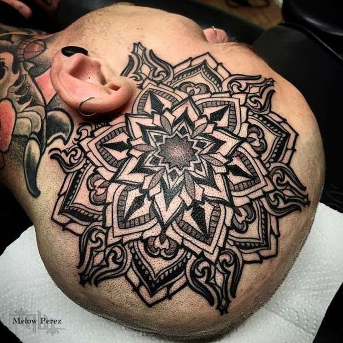 Muž s veľkým tetovaním tetovanie s kmeňovými motívmi, muž s farebným halstattoom, muž s nosom a dvoma piercingmi uší