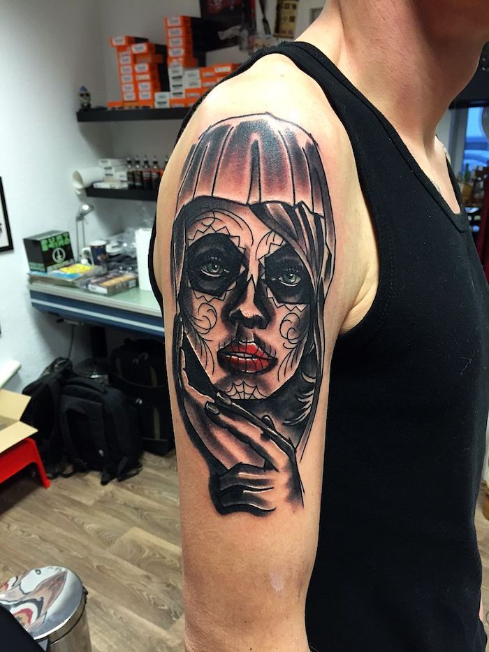 wat betekent la catrina - een man met een hand met een grote zwarte tatoeage met een jonge vrouw met rode lippen, groene ogen