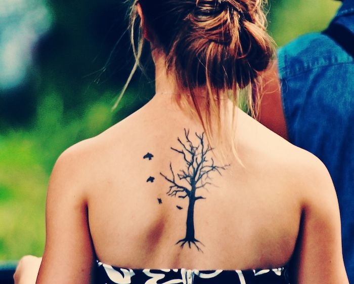 un arbore de tatuaj subțire al vieții, cu câteva păsări mici care zboară
