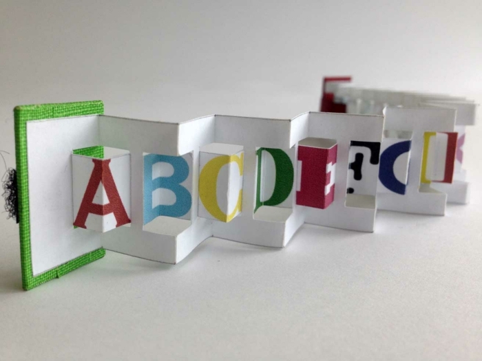 Folder z literami alfabetu w różnych kolorach z zieloną kopertą