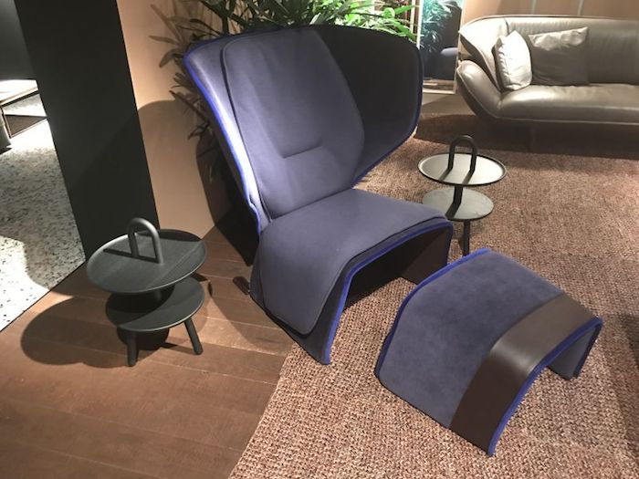 smėlio spalva suprojektuota svetainė su violetinės spintelės kėdės su išmatomis, veidrodis kampe, perėjimas į kitą kambarį