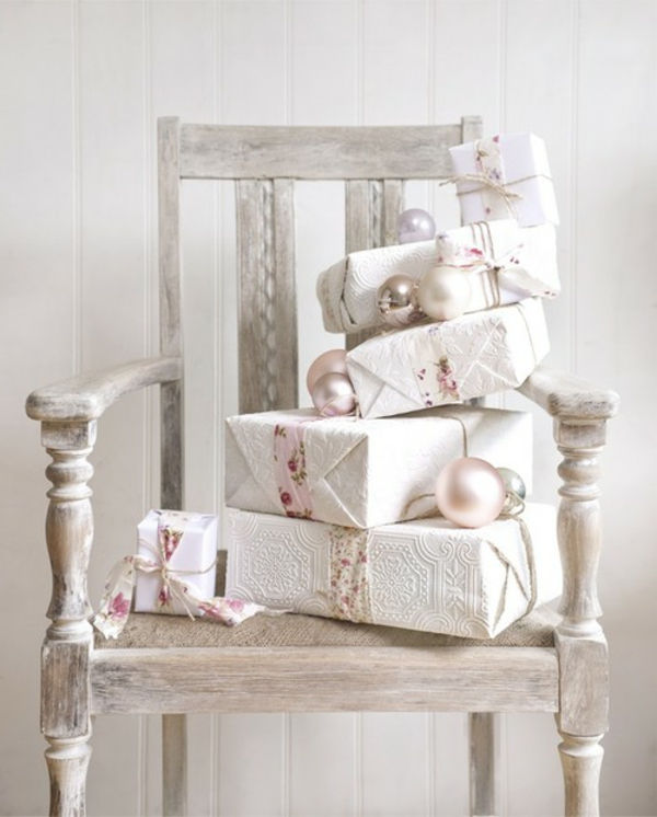 białe świąteczne dekoracje - drewniane krzesło z wieloma białymi prezentami na nim
