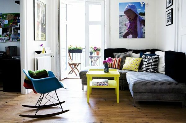 Obývacia izba s pohovkou, žltým stolom a hojdacou stoličkou