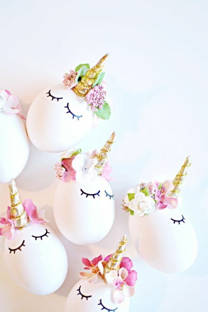 ovos brancos engraçados como unicórnios com chifres dourados e flores para decoração