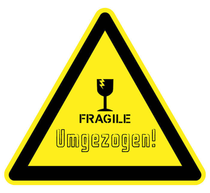 Et morsomt skilt med adressen: Fragile fjernet, gult trekantskjold med svarte kanter og et ødelagt sortvineglass