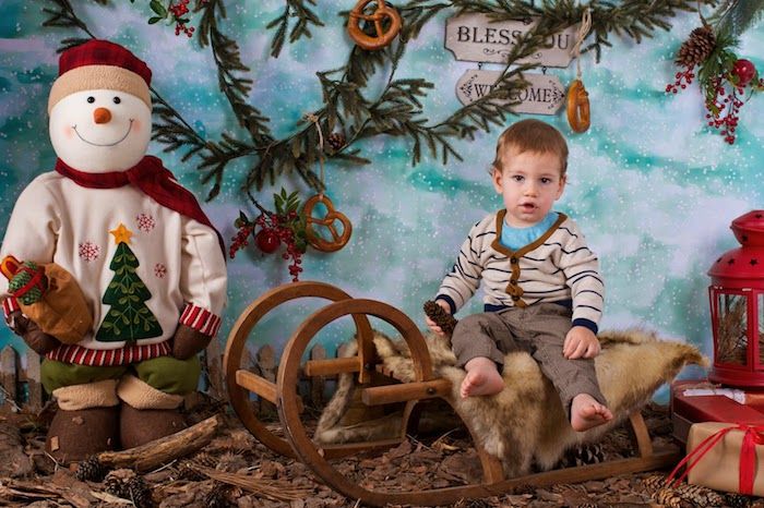 roliga bilder till jul - en pojke på släden och en jultomten bredvid den