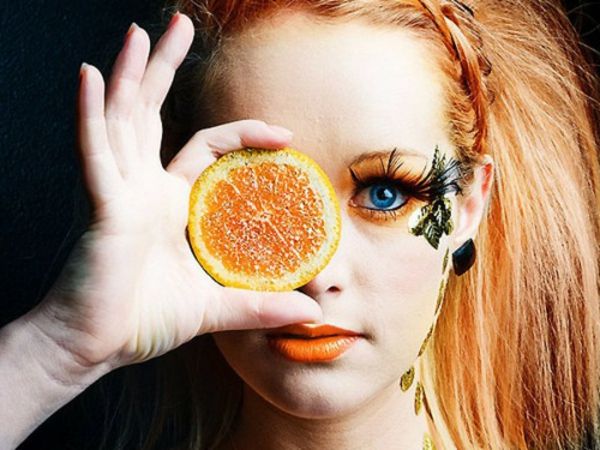 albastru ochi machiaj - femeie cu o felie de portocaliu