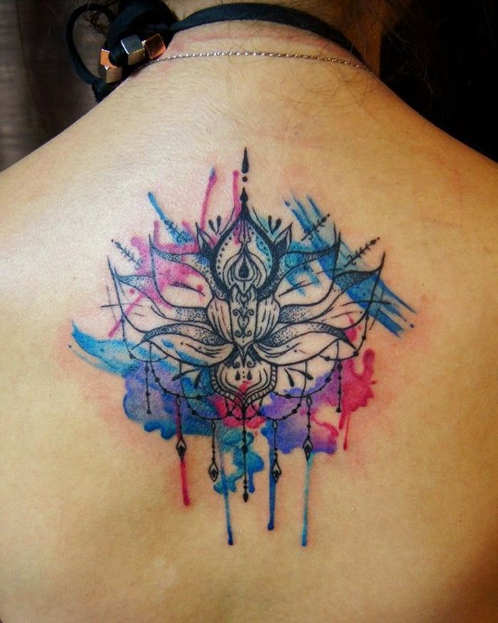 Kobieta z dużym tatuażem z tyłu akwarela w kolorze niebieskim, fioletowym i czarnym, wiele motywów plecionych i łańcuchowych, duży akwarela tatuaż na plecach