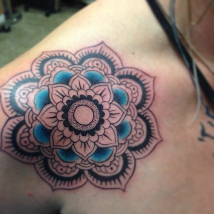 jonge vrouw met kleine schouder tatoeage in zwart en blauw, bloem tatoeage op de schouder, blonde vrouw met twee kettingen