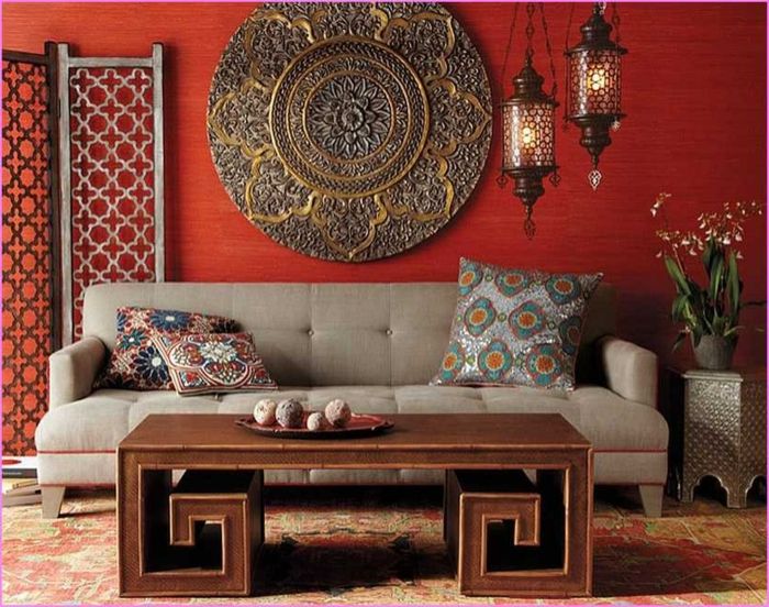 Kinų svetainė su raudonomis sienomis, apvalios Sienų apdaila pagaminta iš metalo, akordeonas pertvarų apdailai, ilgas medinis stalas su netipinių dizaino, pilkos spalvos sofos su porankiais, trys rytietiškų sofos pagalvėlių, nedidelis staliukas pagamintas iš metalo su augalo ant dviejų stiklo šviestuvai, kiaušinių krūva knygų Kitas sofa
