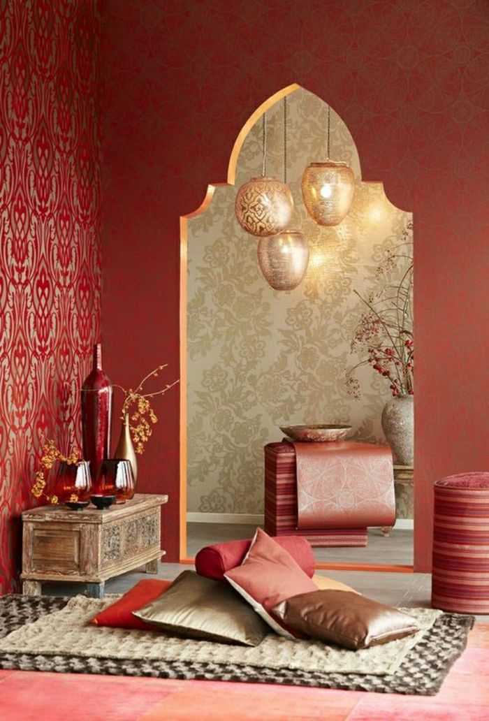 Avslapningsrom med røde terrakottavegger, liten dekorativ treboks med fire vaser, vegg med mønstret tapet, dekorativ vase med Ikebanadeko i gangen