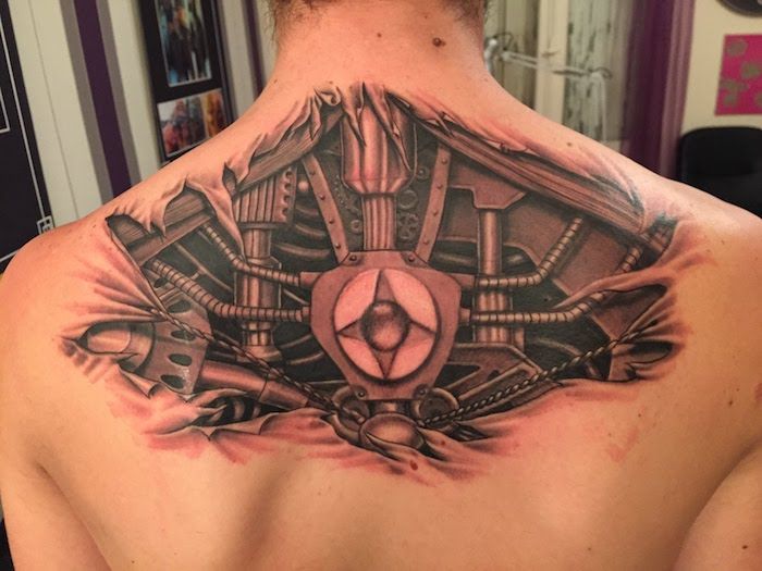 tattoo motieven mannen, man met biomechanische tatoeage op keerzijde