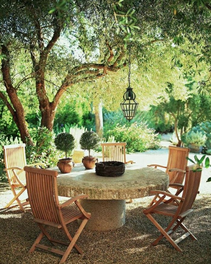 Medelhavsträdgårdsdesign-stenbord-trä-stolar-lantern