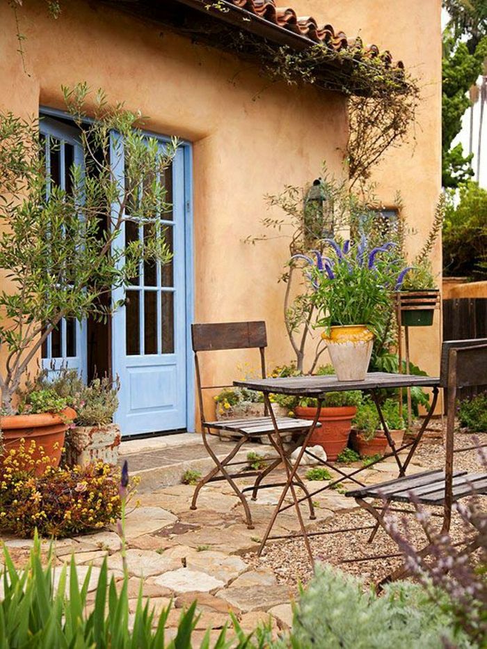 Middelhavshagedesign-bord-stoler-smijern blomsterpotte blå døren
