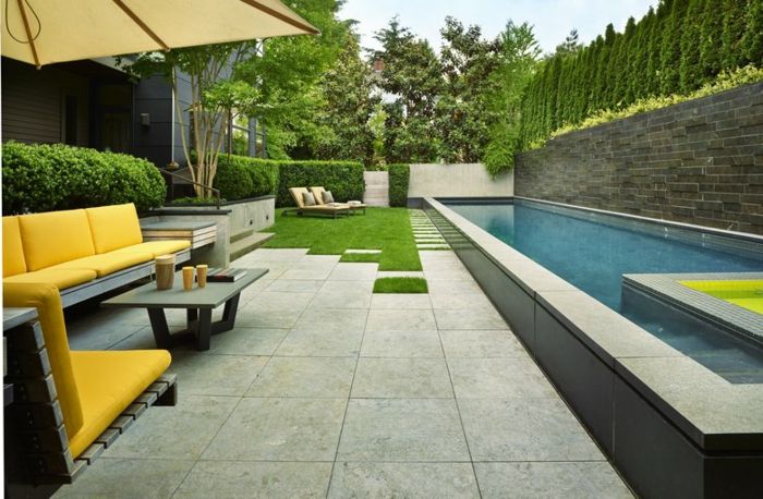 yeşil çim şezlonglar sarı bahçe mobilyaları bir yüzme havuzu purist bahçesi