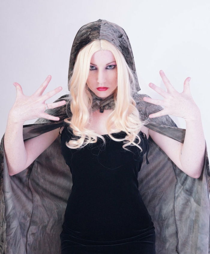 Cosplay de vrăjitoare cu păr blond și coafură mijlocie, rochie neagră